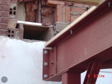 Anchored steel to foundation Partially removed exterior brick masonry prior to rough framing